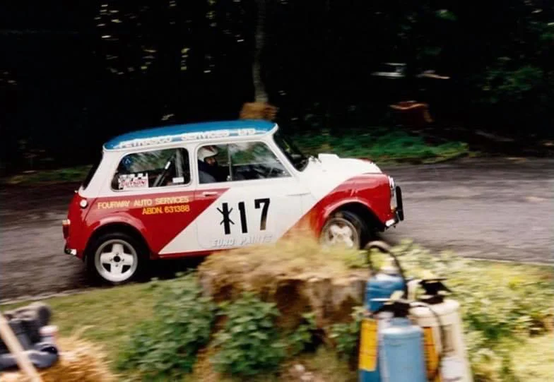 Red and white Classic Mini number 17 on forest rally stage